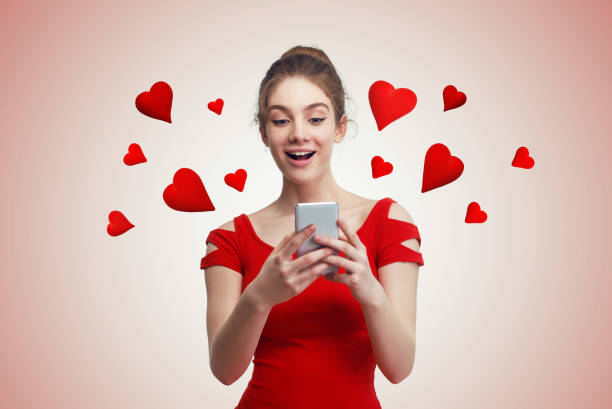 istock Cute young woman texting on the phone, with red hearts flying 1299803724