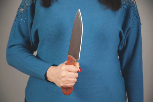 istock woman hand holding knife in back 1299805454