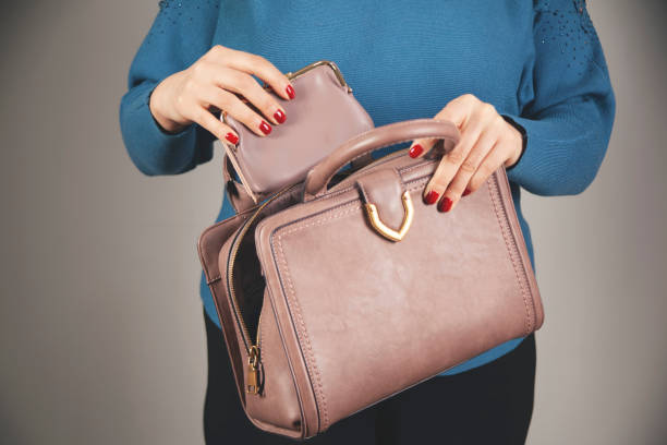 istock woman hand wallet with bag on dark background 1299805461
