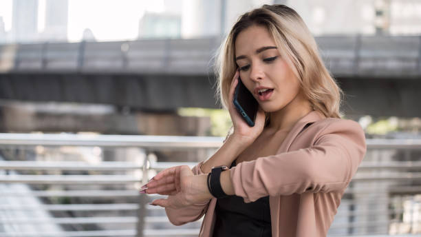 istock Businesswoman talk over phone check time 1299806419