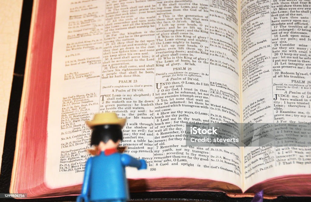 Toy Reading Bible Toy figurine reading old opened Bible. Action Figure Stock Photo