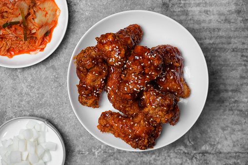 Top view Korean spicy fried chicken with side dishes.