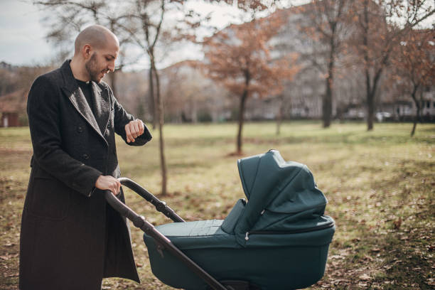 istock Young father with baby carriage in park 1299807118