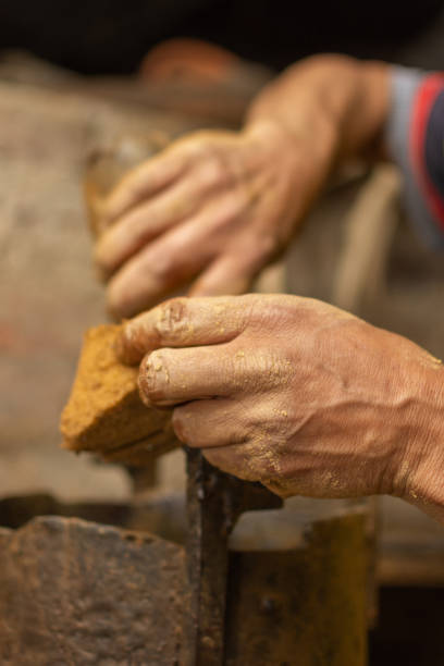 istock Sculptor's hand stained with clay preparing molding machine. Shallow depth of field 1299807818