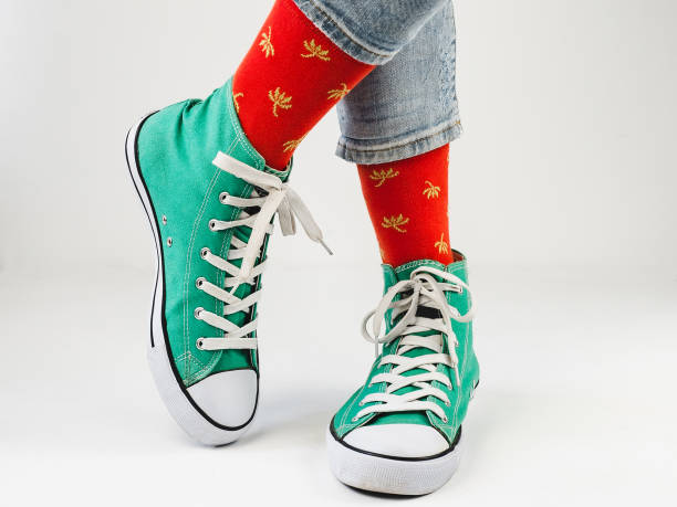 istock Green sneakers and funny socks on a white background 1299808599