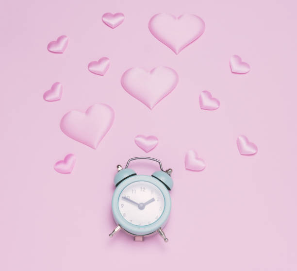 istock Top view flat lay pink hearts and alarm clock pastel pink background. 1299809689