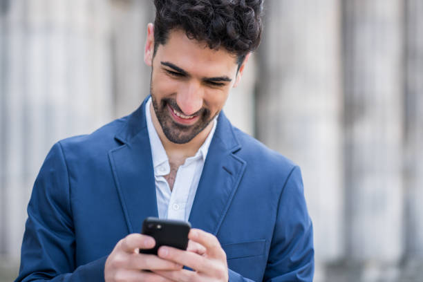 istock Business man using his mobile phone outdoors. 1299811160