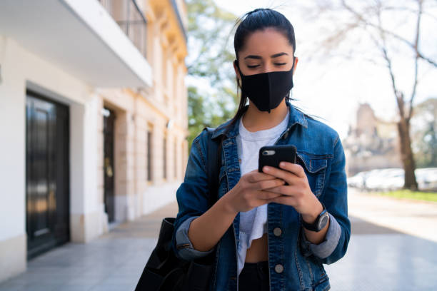 istock Young woman using her mobile phone outdoors. 1299811162