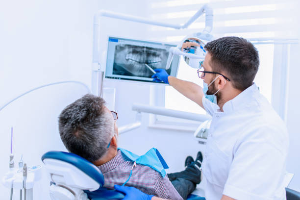 стоматолог, объясняющий рентген зубов пациенту мужского пола - dentists chair people care medical equipment стоковые фото и изображения
