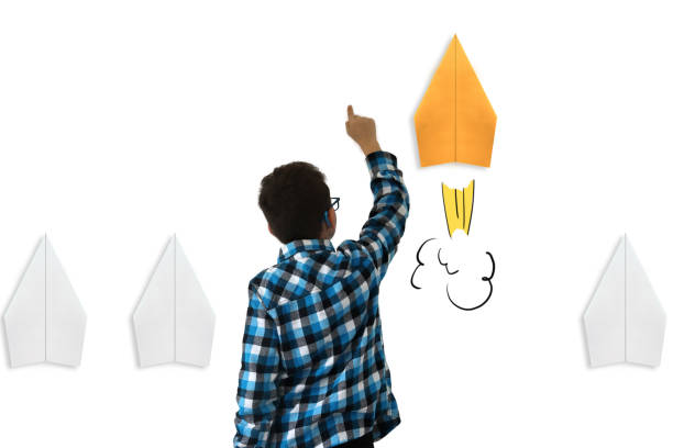 business-wettbewerb gewinner boy-kind-papier-flugzeug rakete helle idee innovation - moving up child pointing looking stock-fotos und bilder