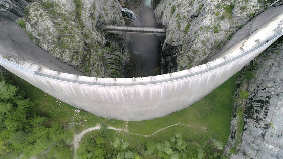 High perspective view of Vajont Dam (or Vaiont Dam), which is a disused dam in northern Italy. It is one of the tallest dams in the world, with a height of 262 m (287 yards). On 9 October 1963, during initial filling, a landslide caused a mega tsunami in the lake in which 50 million cubic metres of water overtopped the dam in a wave of 250 metres (270 yd), leading to the complete destruction of several villages and towns, and estimated between 1,900 and 2,500 deaths.