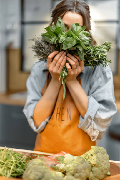 istock Woman with fresh spicy herbs on the kitchen 1299817157