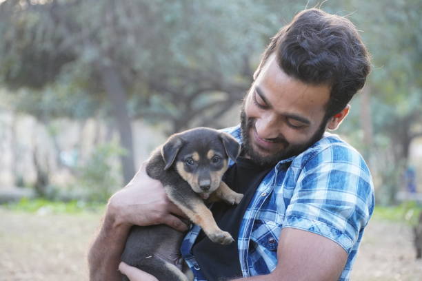 istock young boy with a cute puppy in park 1299818802