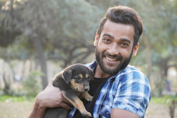 istock young boy with a cute puppy in park 1299818876