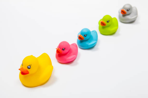 istock Many colorful rubber ducks on white background 1299821811