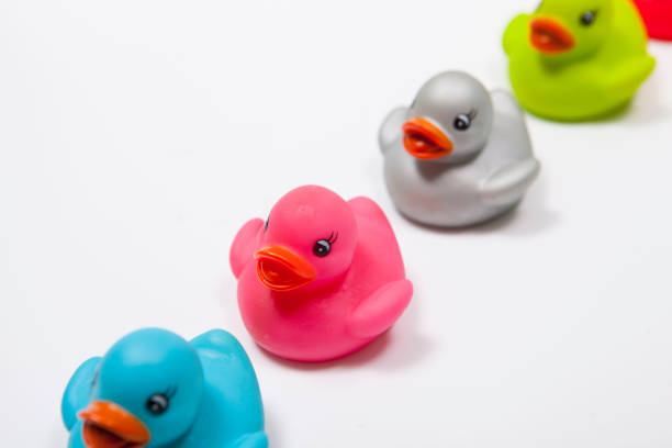 istock Many colorful rubber ducks on white background 1299821851
