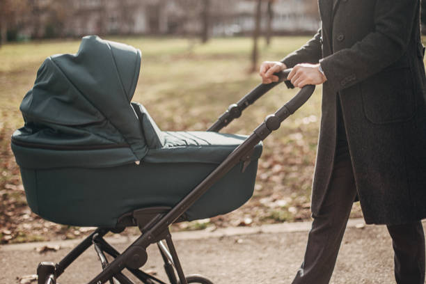 istock Young father taking a walk with baby carriage in park 1299821950