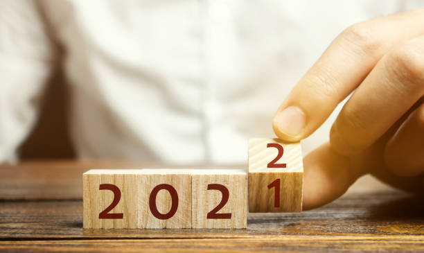 Man flips a block changing 2021 to 2022. New year beginning. Holidays and Christmas. Trends and changes in the World. Build plans and goals. New normal. Summing work done. Man flips a block changing 2021 to 2022. New year beginning. Holidays and Christmas. Trends and changes in the World. Build plans and goals. New normal. Summing work done. 2021 stock pictures, royalty-free photos & images