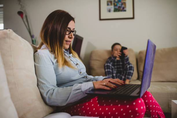 istock Woman working at home with her little son 1299822886
