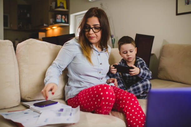 istock Woman working at home with her little son 1299824390