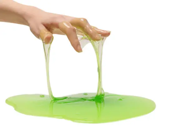 Green slime toy in woman hand isolated on white background.