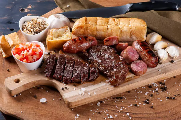 Photo of Typical Brazilian barbecue, with garlic bread, picanha, sausage, vinaigrette and farofa