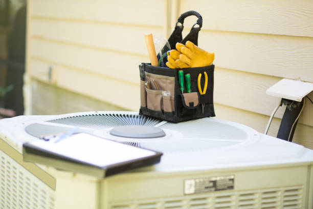 Air conditioning service personnel keep home owner unit running efficiently to help save carbon footprint. stock photo