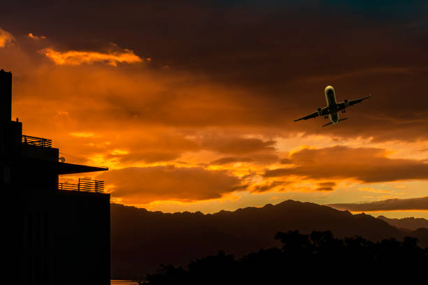 istock Colorful clouds and airplane among clouds above mountains, 1299829567