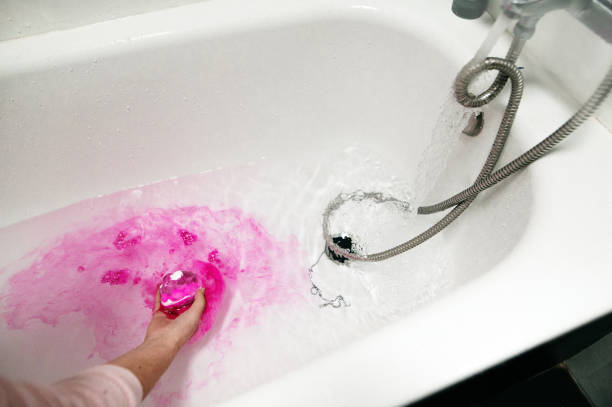 istock Putting a pink bath bomb in a bathtub 1299830472