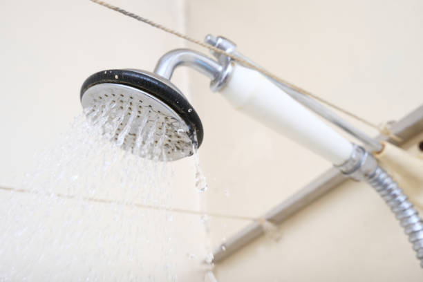 istock Water flowing from an old shower head with ceramic handle with limescale needed to be replaced or decalcified 1299830597