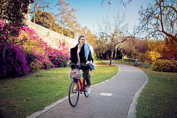 istock Young woman is riding bicycle in the park 1299832108
