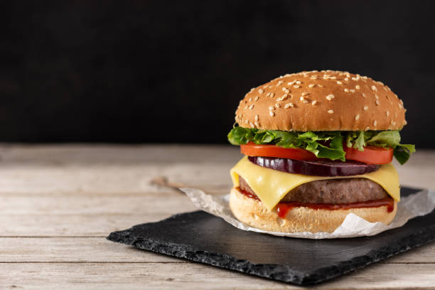 Cheeseburger with beef,tomato, lettuce and onion Cheeseburger with beef,tomato, lettuce and onion on wooden table spanish hamburger stock pictures, royalty-free photos & images