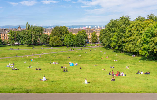A sunny day in Glasgow Individuals and groups of people on the grass at Queens Park in Glasgow's Southside, enjoying some relaxation in the sunshine. glasgow scotland stock pictures, royalty-free photos & images