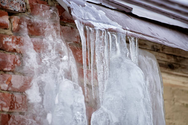 istock a brick wall covered in ice. icicles on the roof 1299832385
