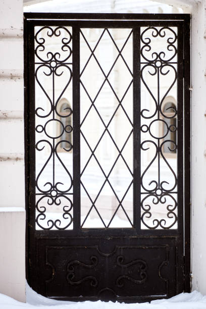 istock wrought-iron gates in a stone fence, covered with snow 1299832975