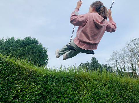 Child playing on the swings outdoors