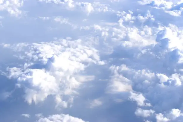 Photo of Dramatic sky with landscape of white clouds viewed from high altitude. Viewed from airplane window.