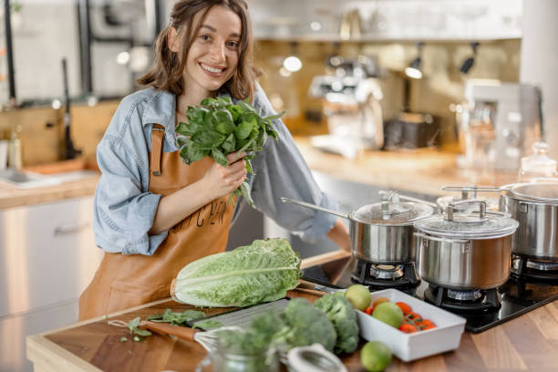istock Woman with fresh green vegetables on the kitchen 1299834966