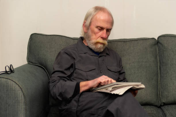 istock Senior man using a tablet while sitting in his living room 1299835774