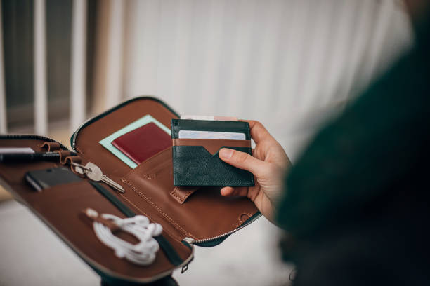 Modern man opened his male purse One man, handsome young gentleman opened his male purse and holding his documents in hand. phone wallet keys stock pictures, royalty-free photos & images