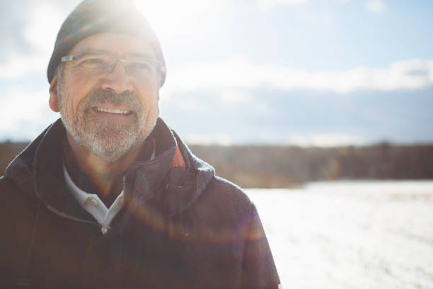 retrato de un hombre atractivo bajo el brillante sol de invierno - snow glasses fotografías e imágenes de stock