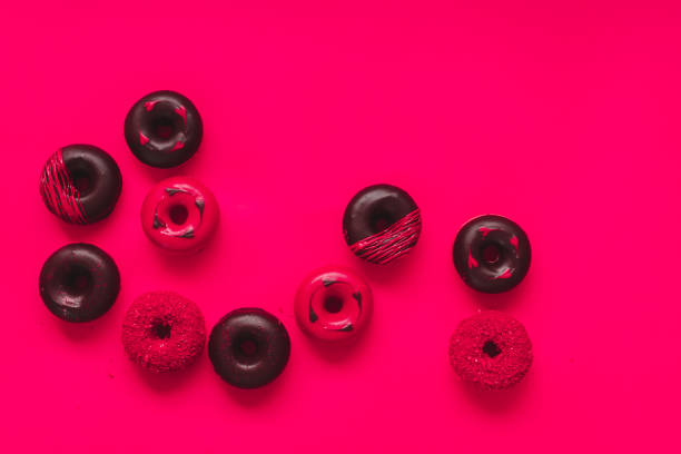 istock Assorted Valentine's Day Donuts. Mini  donuts with chocolate, icing and sugar sprinkles on  vibrant red backdrop 1299839710