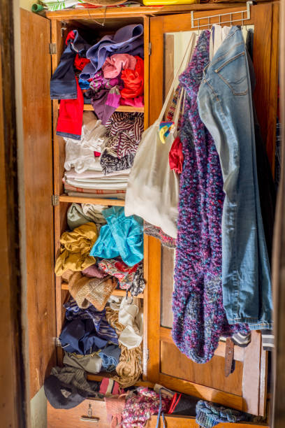 istock Closet clogged with clothes and textiles. Second hand reuse. Decluttering and cleaning the cabinet 1299841069
