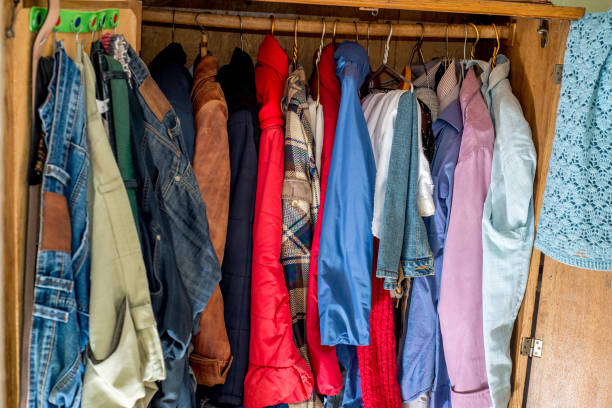 istock Old and new clothes in the closet on hangers and drawers. Second hand reuse. Decluttering and cleaning the cabinet 1299841072