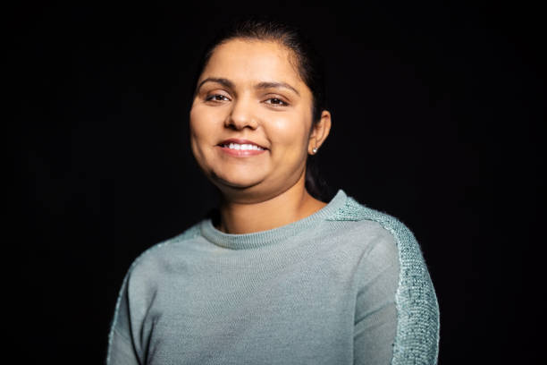 istock Happy Indian woman on black background 1299841100