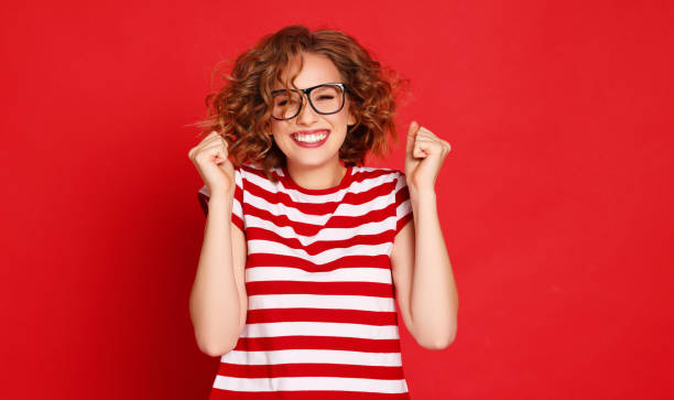 istock Young woman clenching fists in excitement 1299843387