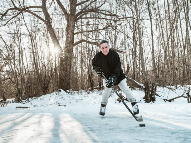 istock Mature man playing hockey outdoors 1299843596