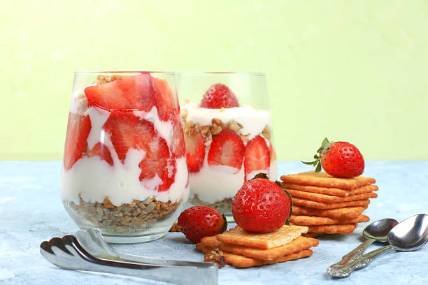 istock Strawberry yogurt with berries, French cracker and muesli on a bright table, fruit salad. Healthy breakfast with ingredients, natural food concept, lifestyle, food for children, selective focus 1299843795