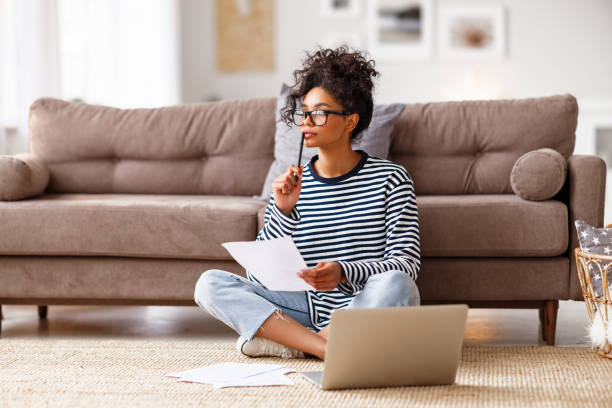 istock Thoughtful ethnic woman doing paperwork at home 1299847990