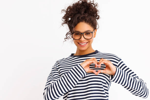 istock Happy young female gesturing heart 1299848080
